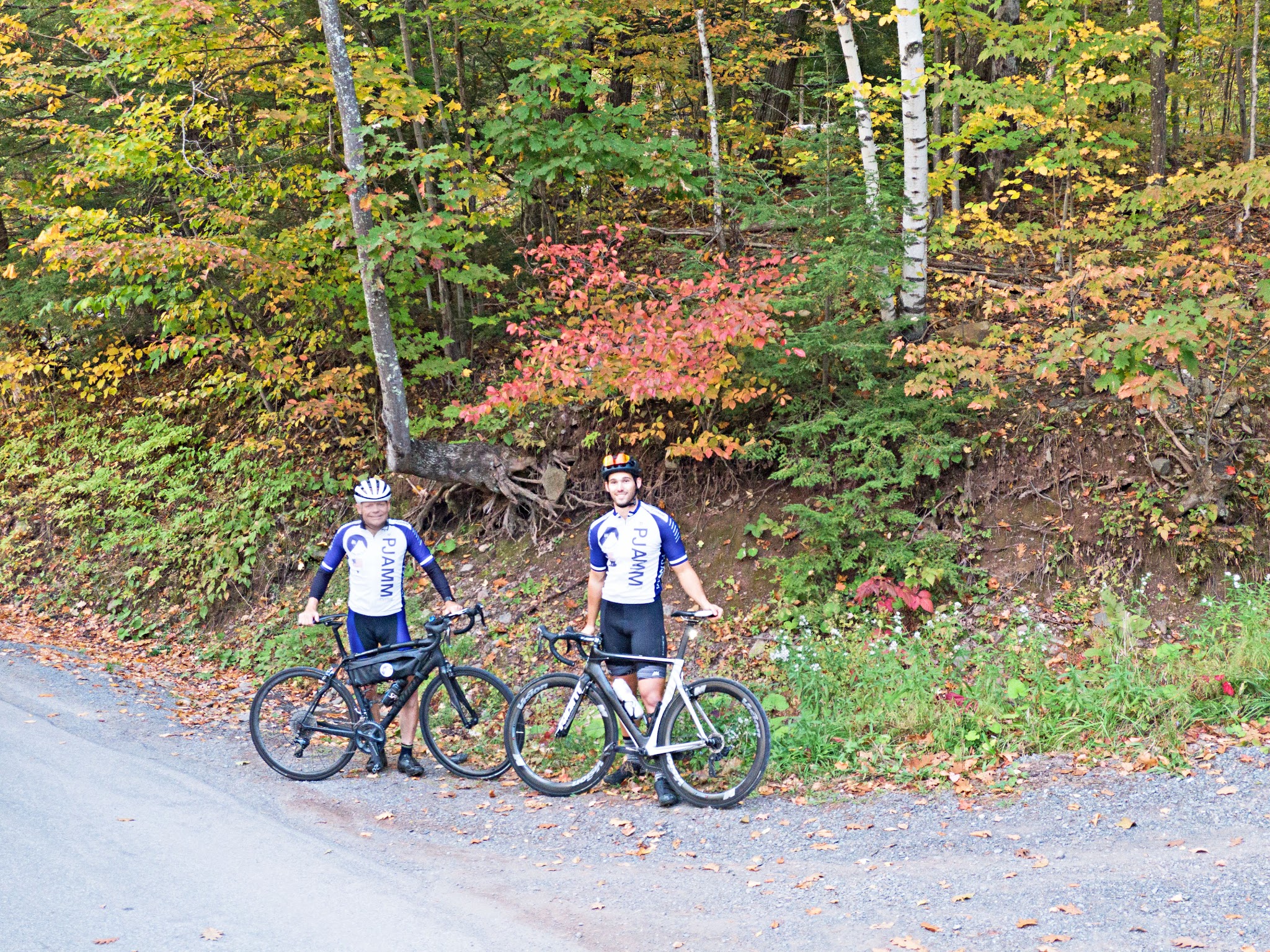 Devil's Kitchen - Platte Clove Road - cyclists in PJAMM Cycling gear standing with bikes along roadside surrounded by fall colors