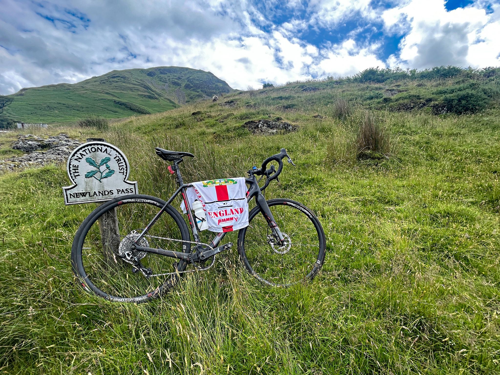 bike parked in green grass next to National Trust sign