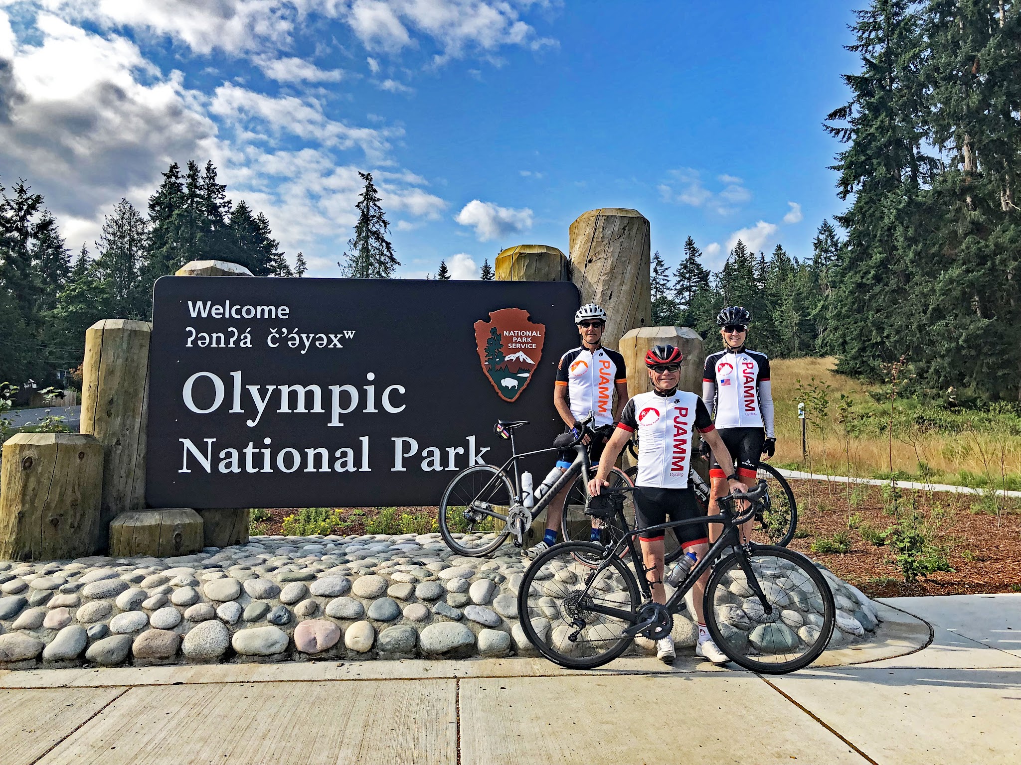 Washington's Top Climbs - cyclists standing in front of sign for Olympic National Park