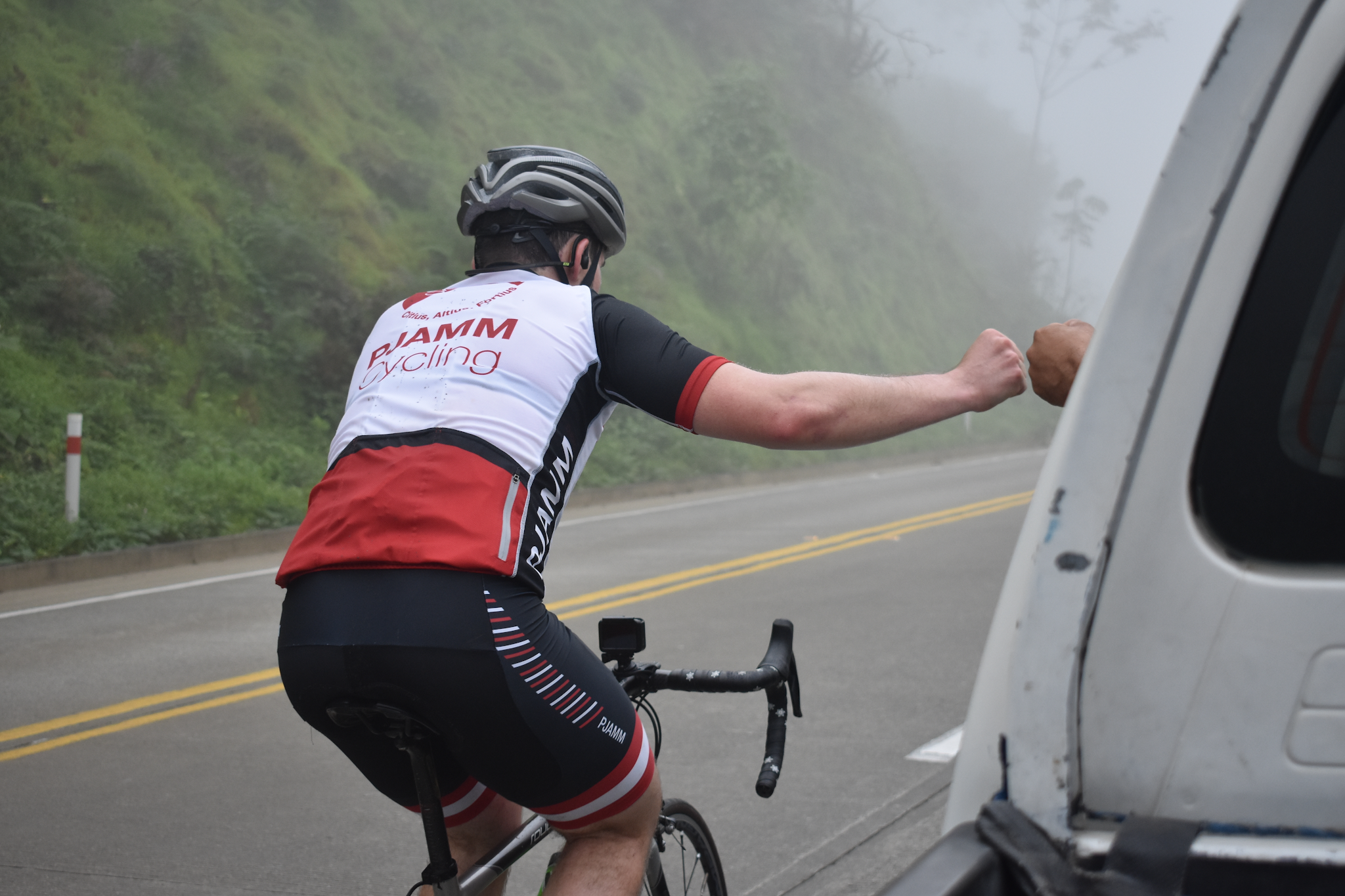 PJAMM Cyclist fist bumps with driver of passing car