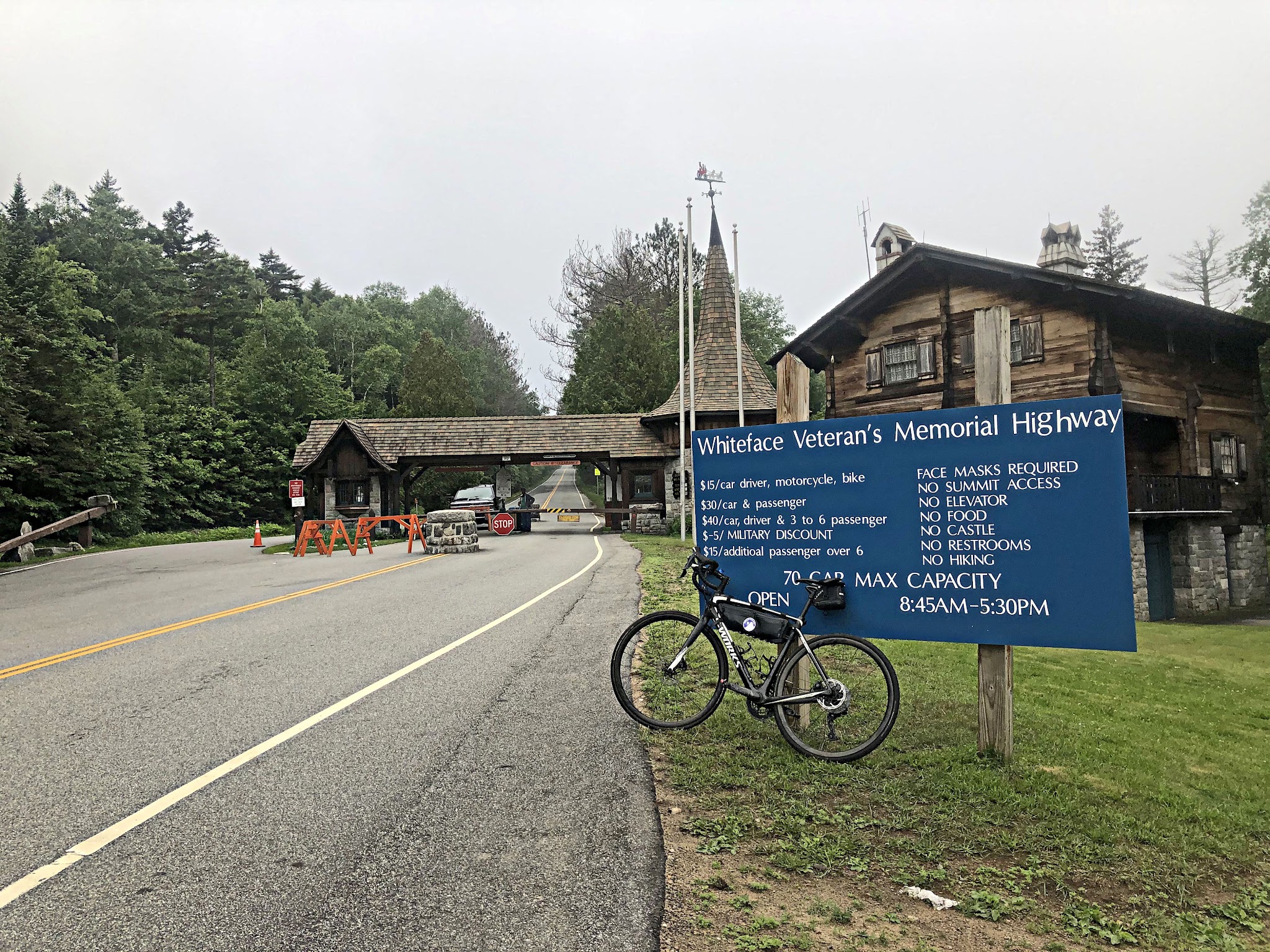 Cycling Whiteface Mountain, Franklin Falls, New York Cycling Whiteface Mountain, Franklin Falls, New York - bike parked in front of sign for Whiteface Veteran's Memorial Highway in front of toll booth on road