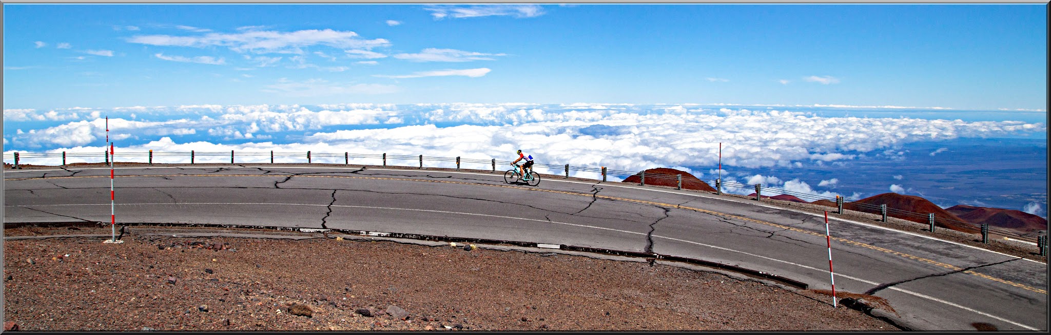 Cycling Mauna Kea from the West  - panoramic photo of PJAMM Cyclist climbing Mauna Kea, above the clouds