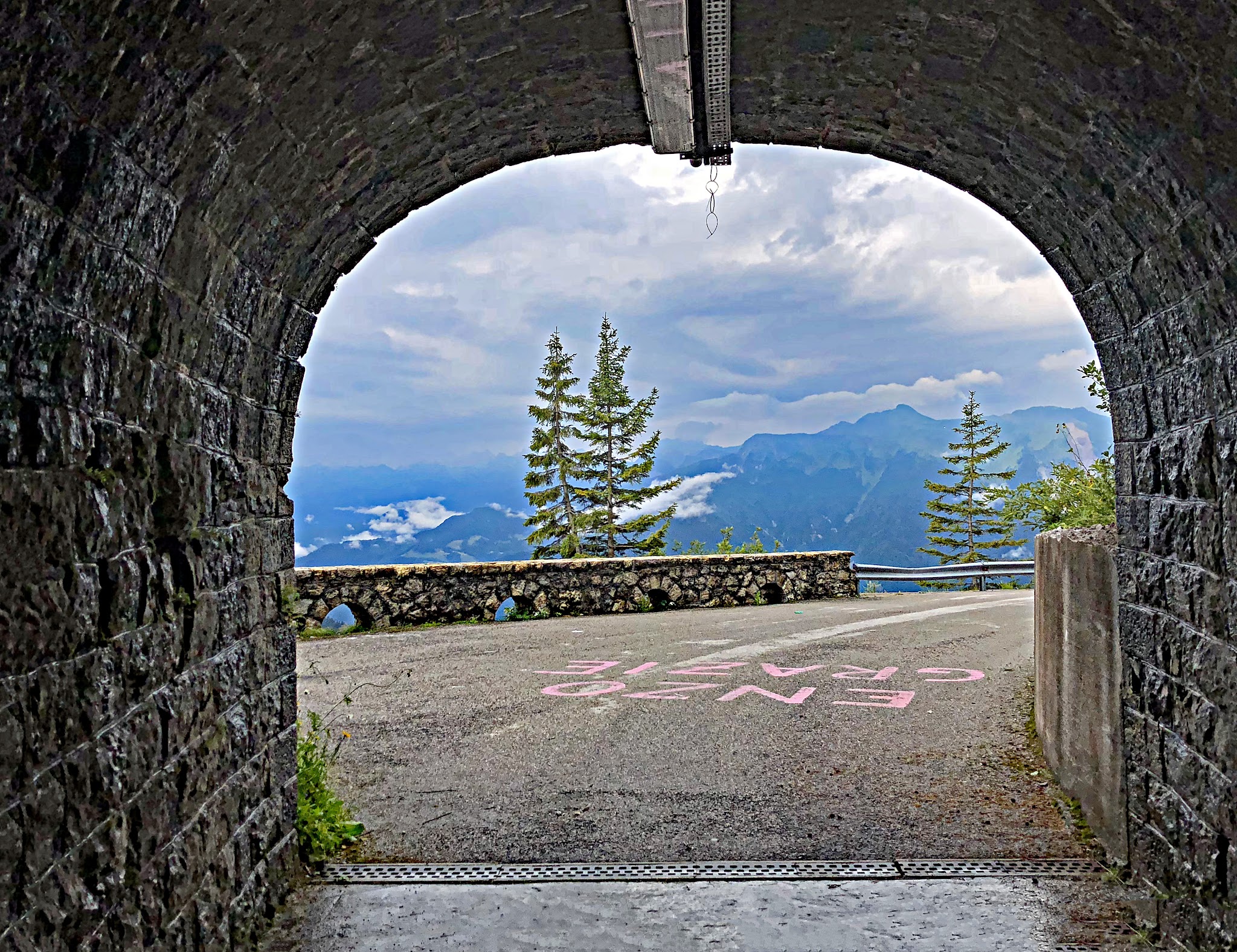 Cycling Monte Zoncolan from Ovaro tunnel with trees in background and giro paint on ground