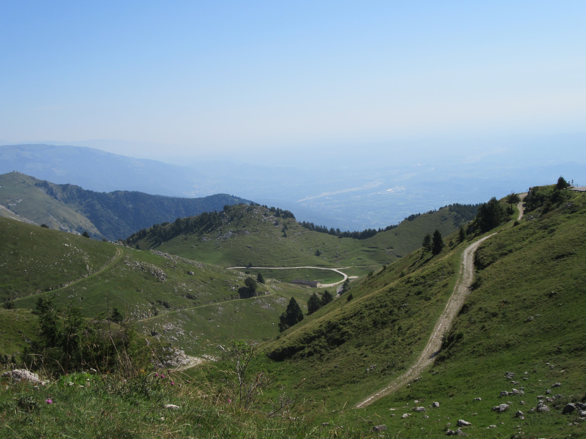 Bike climb of Monte Grappa from Crespano - gravel roadway and city below