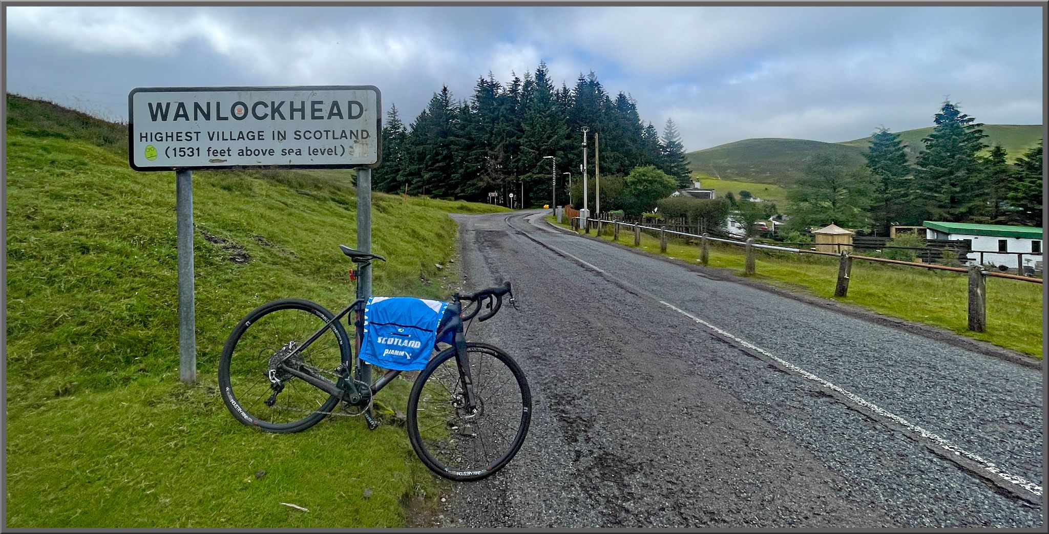 bike parked along roadside next to sign for Wanlockhead, highest village in Scotland