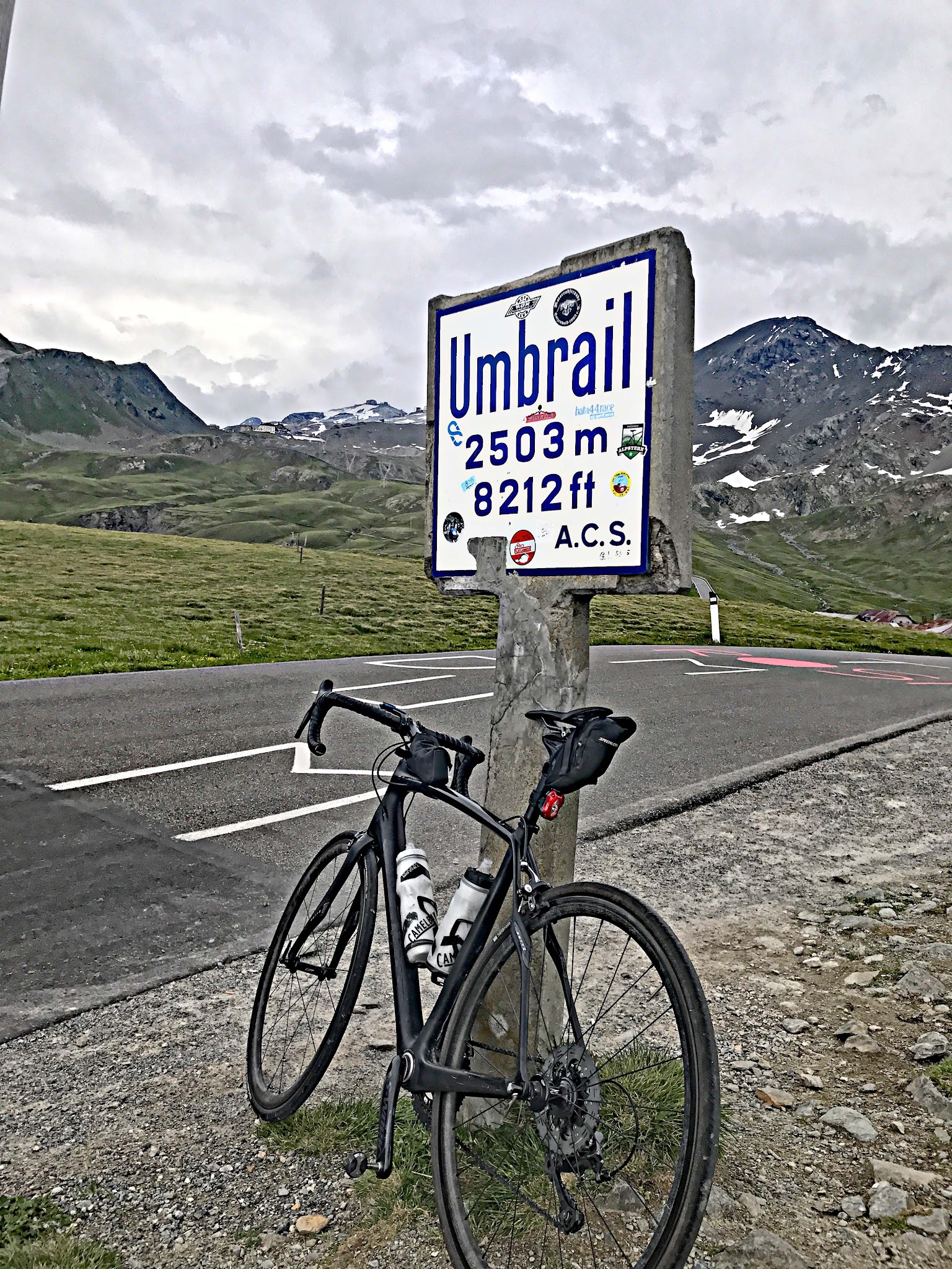 biking Umbrail Pass - pass sign with bike leaning against it