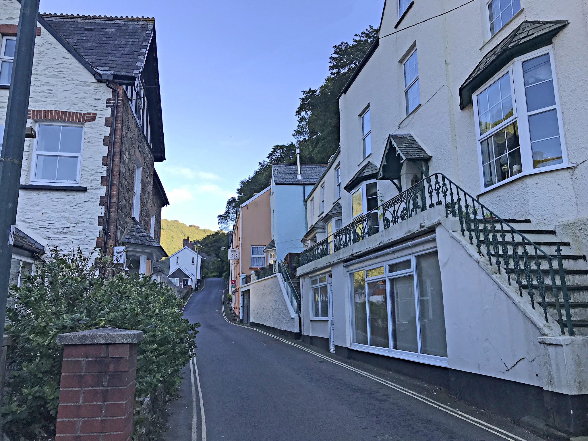 Cycling Exmoor Forest, England - one lane roadway along town of Porlock, buildings facing roadway
