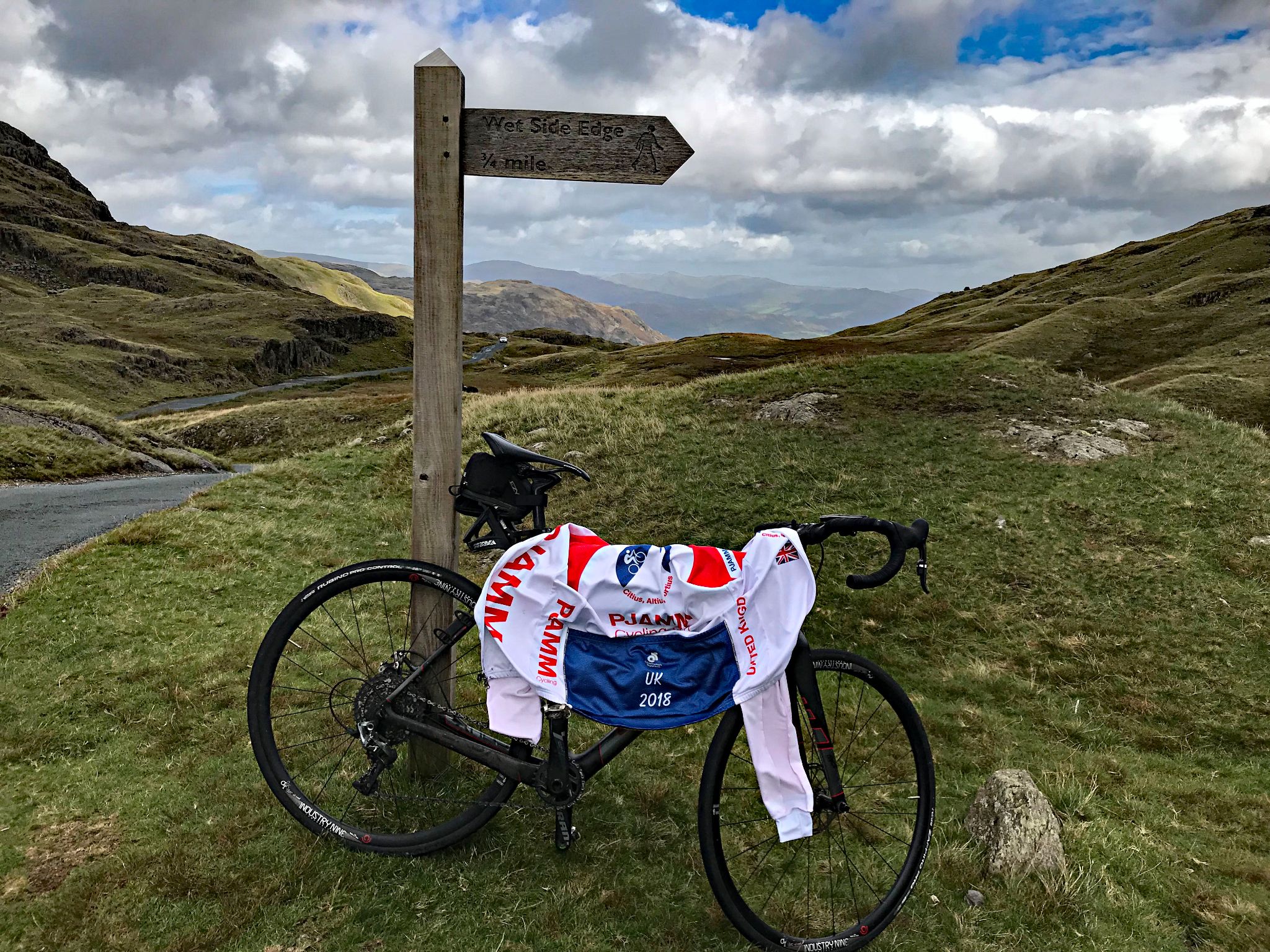 bike parked next to old wooden sign at climb's summit