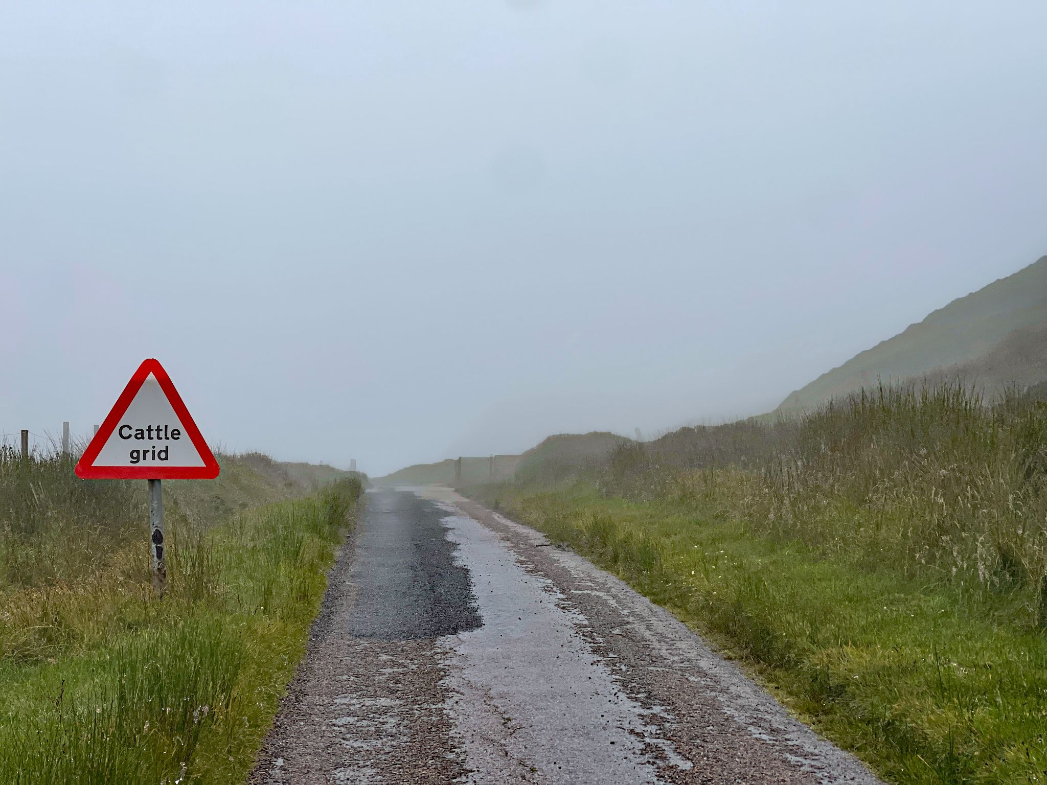 coastal country road with sign reading "cattle grid"