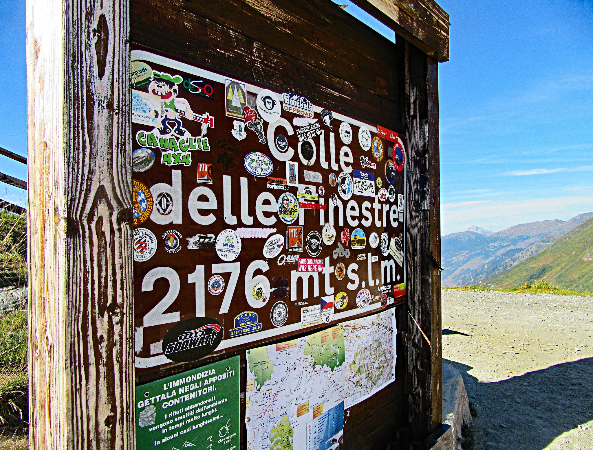 Climbing Colle delle Finestre  by bike - start of gravel - roadway, sign, arch