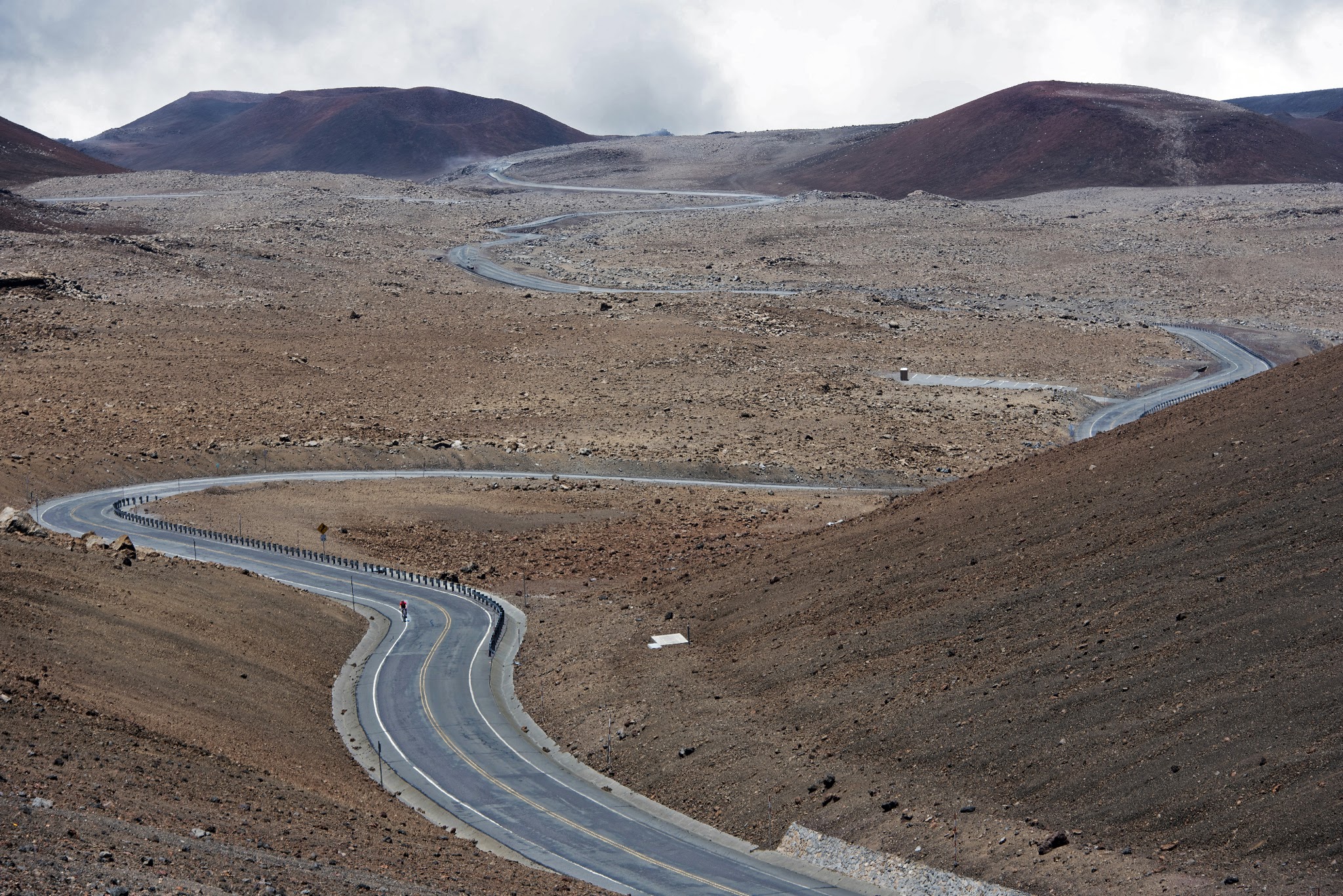 Cycling Mauna Kea - view of clouds, road and volcano near top