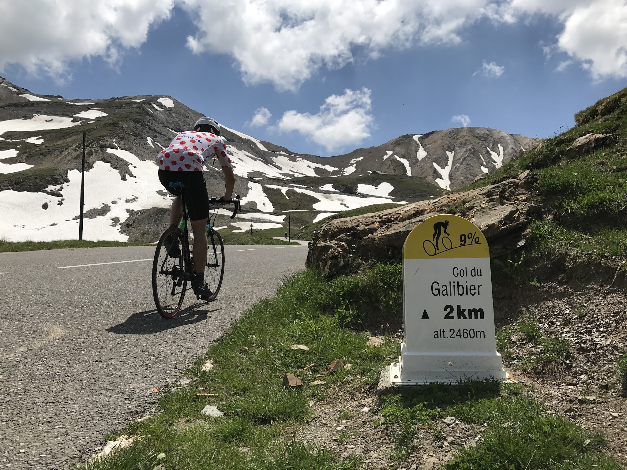 Cycling Col du Galibier - cyclist riding past the  2 km marker