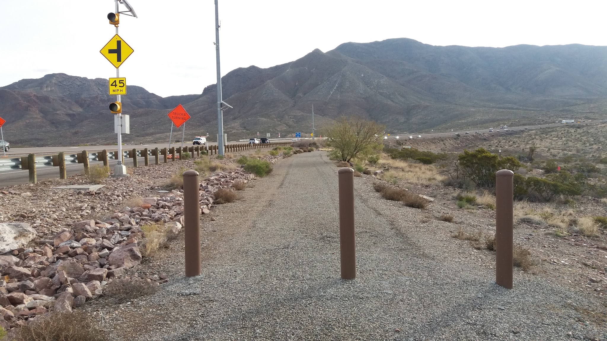 Climbing Smugglers Pass West - Transmountain Drive by bike - gravel path merging onto highway