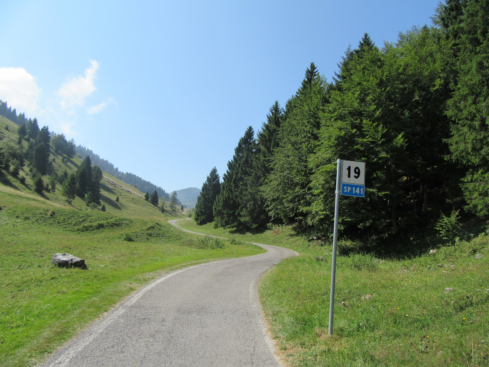 Bike ride up Monte Grappa from Possagno - roadway, meadow, SP 141 km 19 sign
