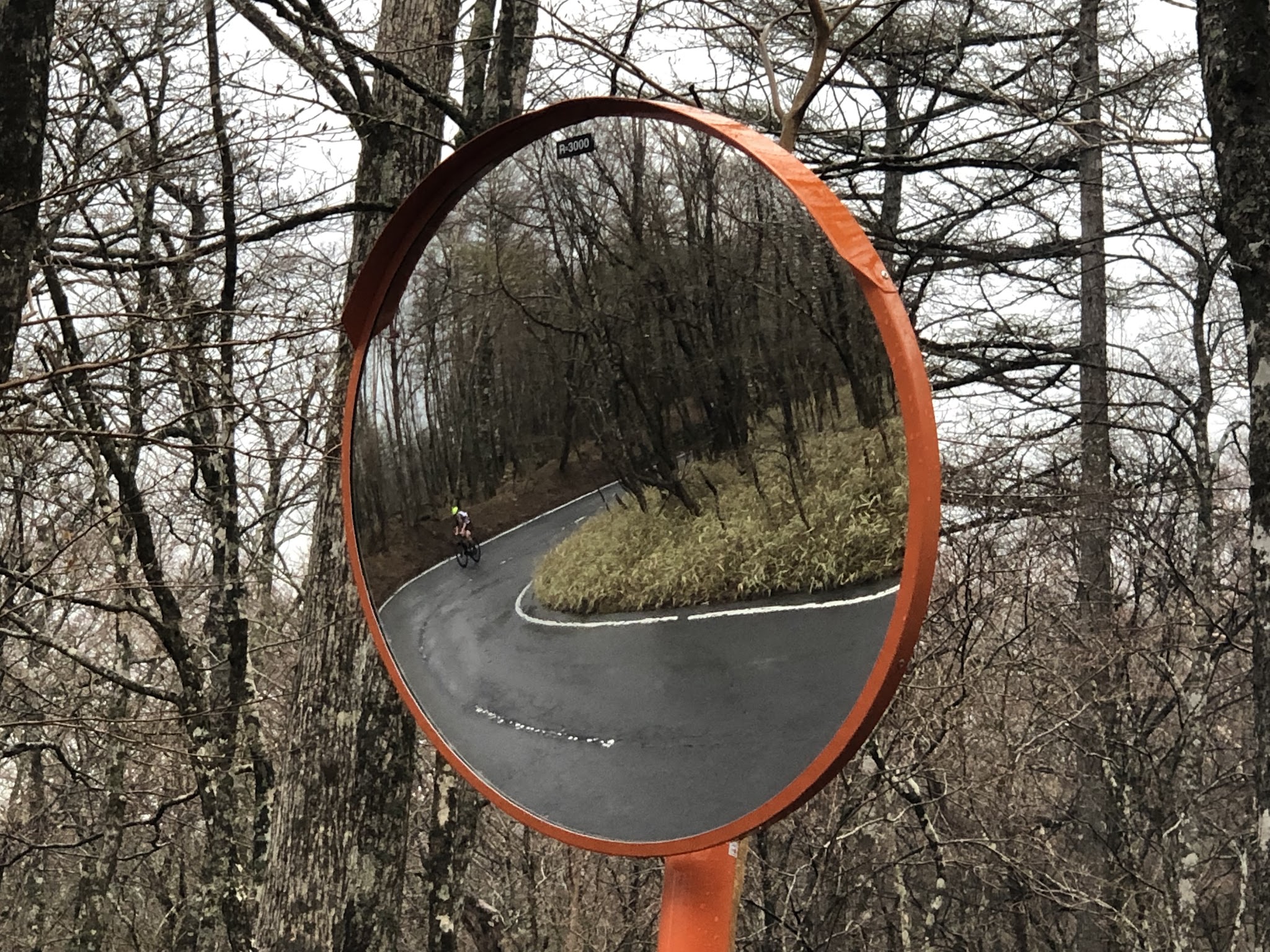 Bike climb Mt. Fuji Azami Line - cyclist on bike shown in roadway mirror