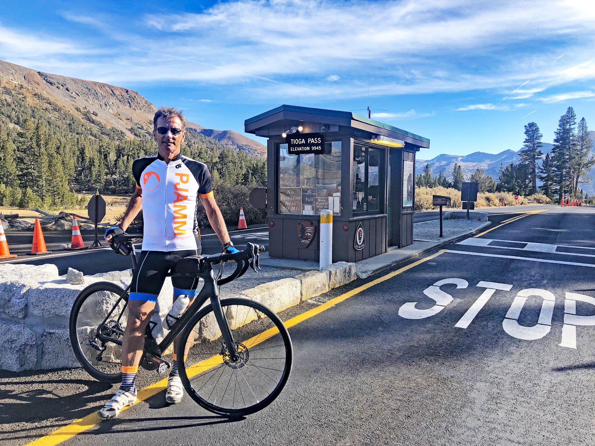 PJAMM Cyclist stands with bike near ticket booth at Yosemite National Park entrance