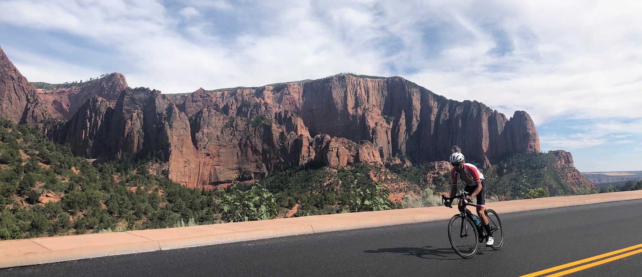 Cycling Kolob Canyon Road - cyclist riding past rock formation