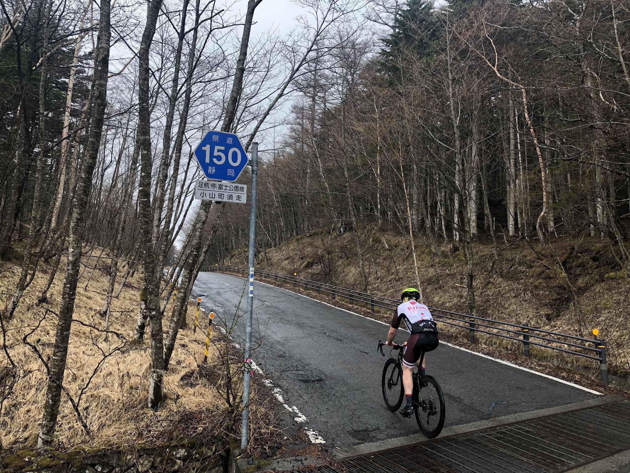 Cycling Mt. Fuji Azami Line - cyclist on road on bike passing Hwy 150 sign