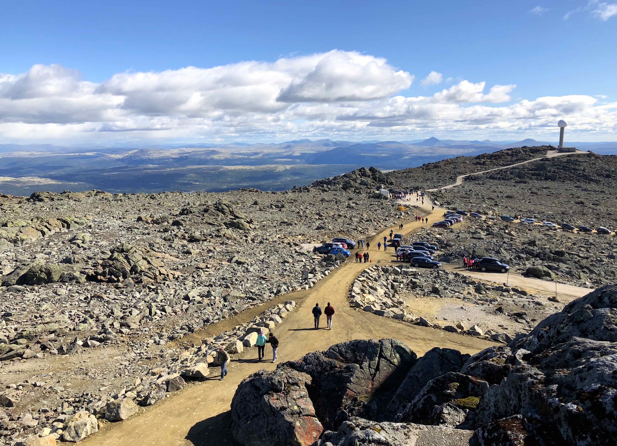 Climbing Tronfjellet - Tron by bike top, radio tower, dirt road, hikers