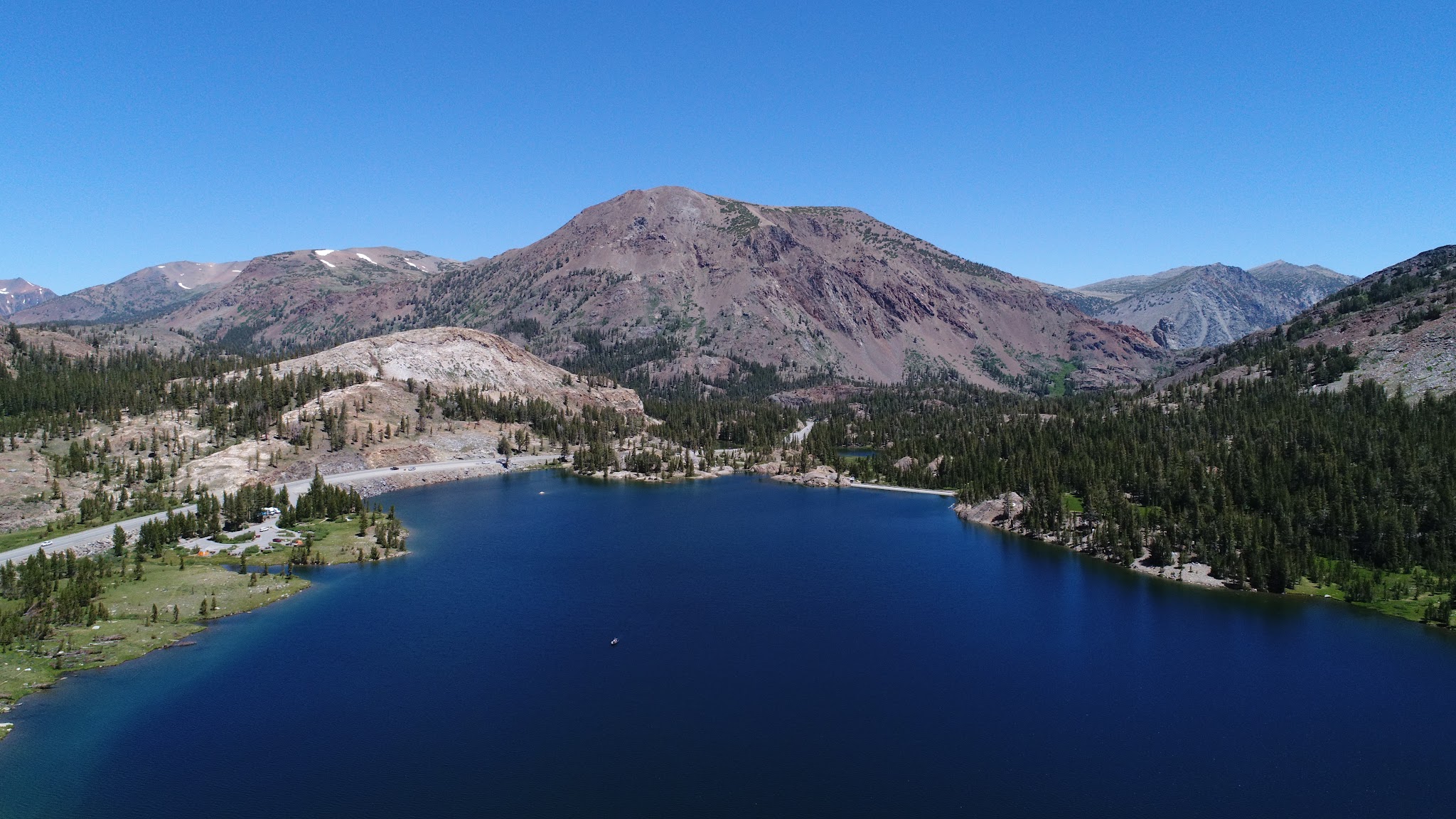 Cycling  Tioga Pass by bike; aerial drone photo of Lake Tioga and hwy 120. 